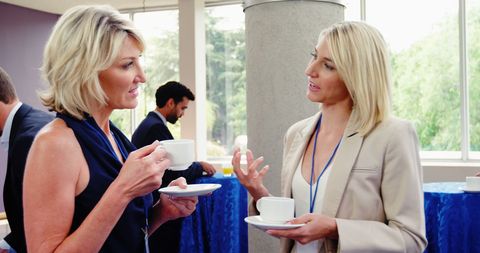 Professional women networking over coffee at business conference
