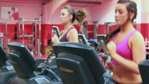 Women Running on Treadmills for Fitness in Gym