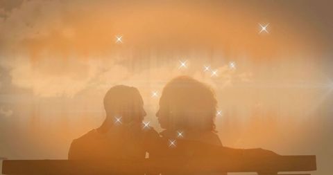 Silhouetted Couple Watching Romantic Sunset with Lens Flare