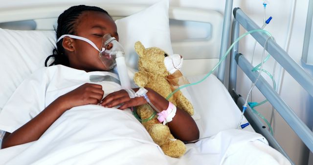 Young patient is recovering in hospital setting, resting with an oxygen mask on face, holding a teddy bear. Depicts pediatric healthcare, hospital care, and recovery. Suitable for themes of children's health, medical services, and hospital care for kids.