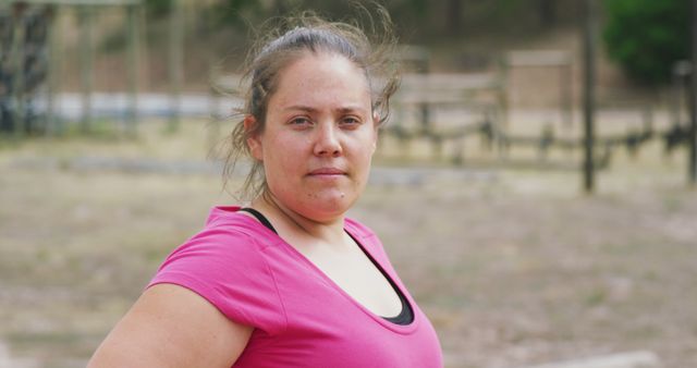 Portrait of caucasian woman wearing pink t-shirt looking at camera. Female fitness, challenge and healthy lifestyle.