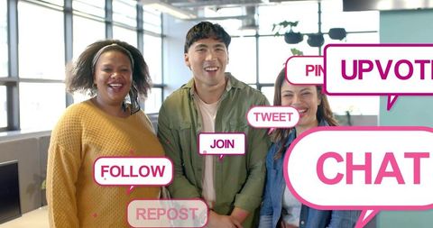 Smiling diverse team posing in bright open-plan office with social media speech bubbles