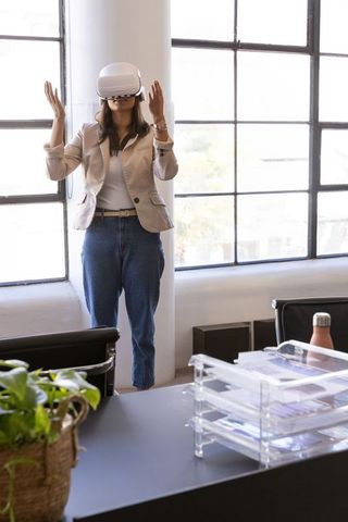 Businesswoman wearing vr headset and gesturing while exploring virtual workspace