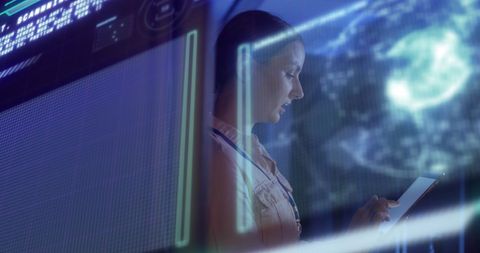 Female engineer analyzing data in futuristic server room