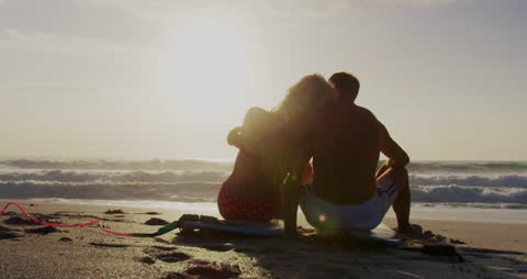 Couple Enjoying Sunset by the Ocean Shore