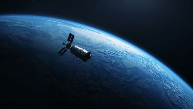 Cylindrical Satellite Orbiting Blue Earth Limb with Solar Panels and Backlit Horizon