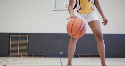 Athletic Female Basketball Player Dribbling Indoor Court