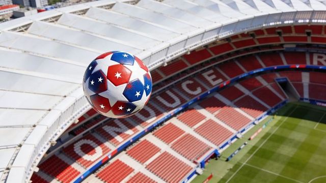 Hovering patriotic soccer ball featuring red and blue stars above empty stadium arena