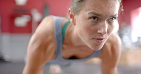 Focused Athlete Holding Plank Position in Gym