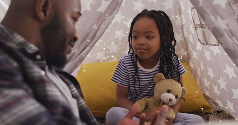 Father and daughter sharing quality time in cozy indoor tent