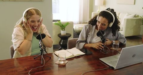 Two engaged women hosting a podcast together with microphones