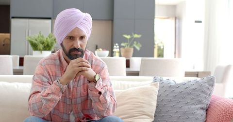 Thoughtful Indian Man in Turban Relaxing at Home