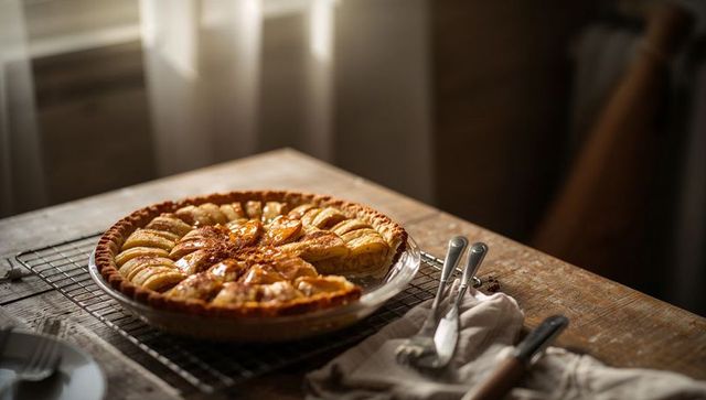 Apple Tart Cooling on Rustic Wooden Table Bathed in Warm Sunlight for Cozy Kitchen