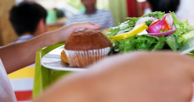 Person Holding Plate with Muffin and Fresh Salad in Cafeteria - Download Free Stock Images Pikwizard.com