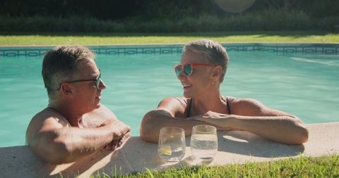 Senior couple relaxing in tranquil backyard pool setting