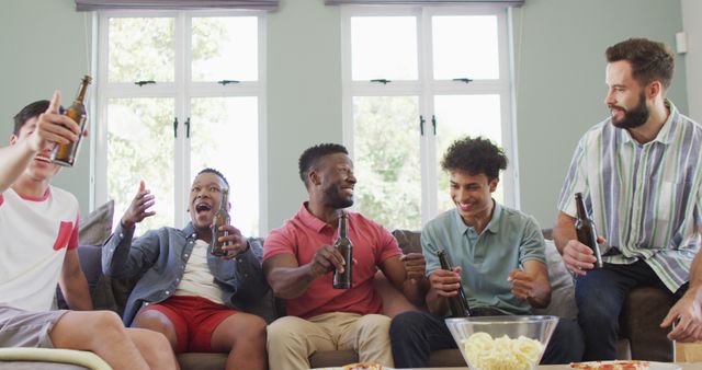 Group of diverse friends sitting on a couch, enjoying beer and snacks while laughing and cheering. Ideal for depicting social gatherings, friendship, leisure activities, celebrations, and weekend relaxation. Suitable for use in advertisements, blog posts, and social media campaigns focused on lifestyle, socializing, and community engagement.