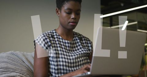 Young African American Woman Working on Laptop with Digital Overlay