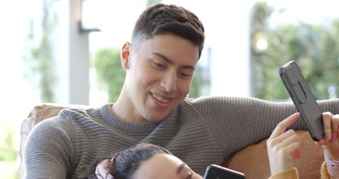 Couple Sharing Relaxed Smartphone Moment on Leather Couch