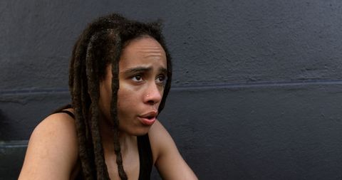 Exhausted African American Woman with Dreadlocks Sitting Tired Outdoors