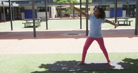 Young Girl Practicing Yoga Outdoors in Schoolyard