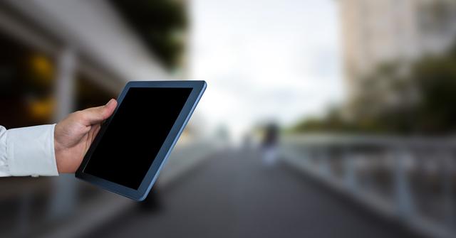 Hand Holding Tablet with Blurred Urban Background - Download Free Stock Photos Pikwizard.com