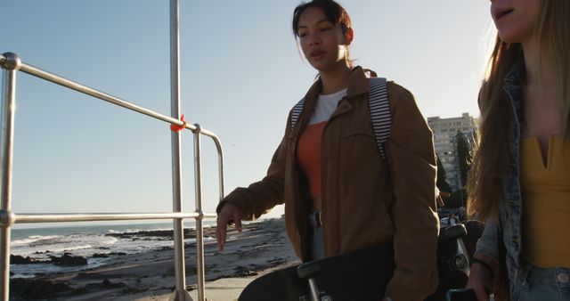 Young Women Walking with Skateboard on Beachfront Boardwalk - Download Free Stock Images Pikwizard.com