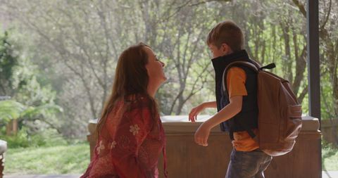 Mother Embracing Son with School Bag in Home Entryway
