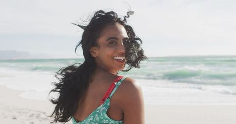 Joyful Woman with Windblown Hair Enjoying Beach