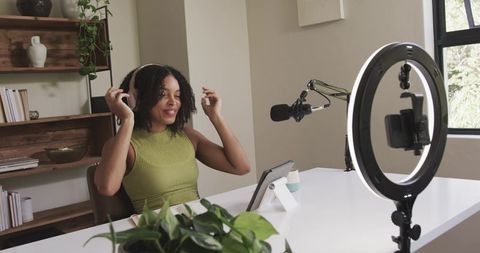 Content creator preparing podcast with ring light and mic in bright home studio