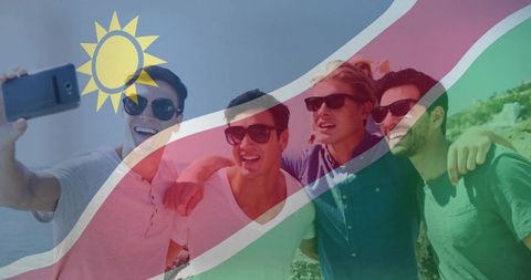 Young men taking selfie on rocky coast with namibia flag overlay celebrating summer travel