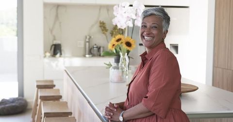 Smiling Woman with Short Gray Hair in Stylish Modern Kitchen