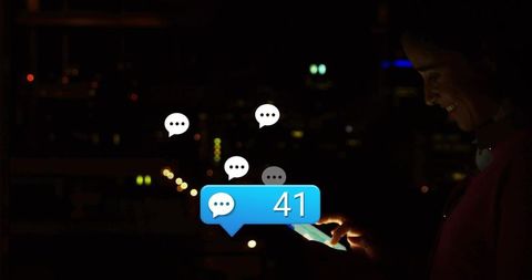 Woman tapping smartphone at night showing message bubbles 41 notifications urban bokeh