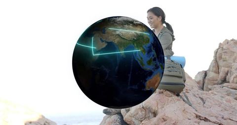 Wanderlust Hiker Exploring Digital World Map on Coastal Rocks