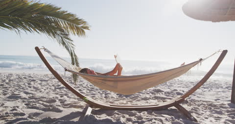 Woman Relaxing in Beach Hammock with Tablet