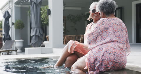 Senior African American Women Enjoying Poolside Conversation