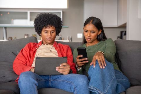 Diverse Couple Relaxing with Technology at Home