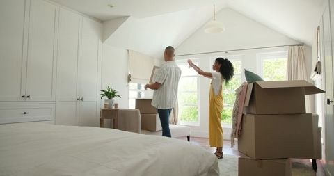 Couple Unpacking Boxes Organizing Modern Bedroom