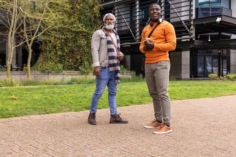 African american father and son walking urban plaza sharing conversation and smiles
