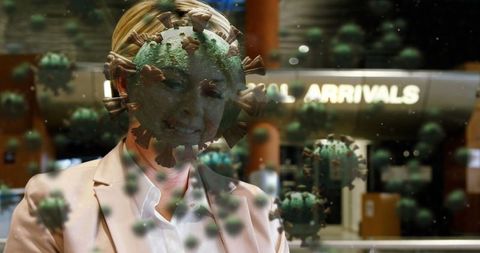 Smiling Businesswoman at Airport Surrounded by Digital Coronavirus Visuals