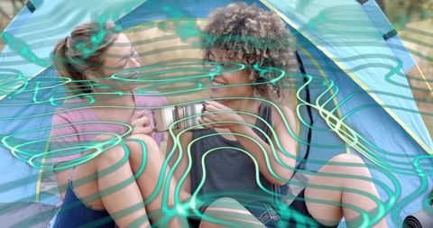 Friends camping together sharing metal mug inside bright dome tent with teal overlay