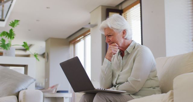 Senior woman thoughtfully using laptop at home - Download Free Stock Images Pikwizard.com