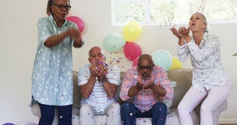 Seniors Celebrating with Confetti and Balloons Joyfully at Home