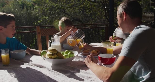 Family Having Breakfast on Sunny Balcony With Fresh Juice and Fruits - Download Free Stock Images Pikwizard.com