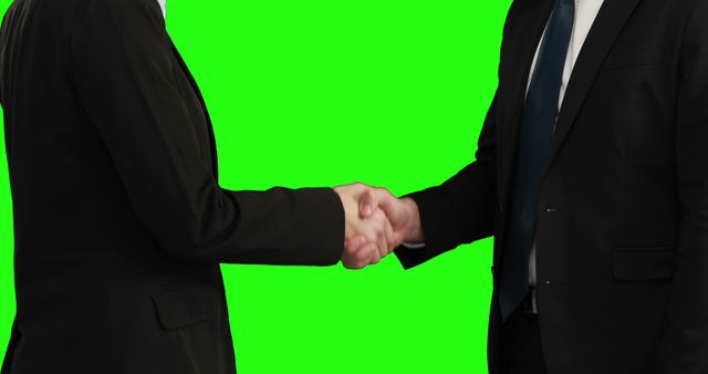 People shaking hands against a green screen background, making it ideal for various professional and business contexts. It can be used for presentations, advertisements, or promotional materials featuring themes like networking, corporate dealings, or forming partnerships. The green screen allows for easy integration into different backdrops or settings after editing.