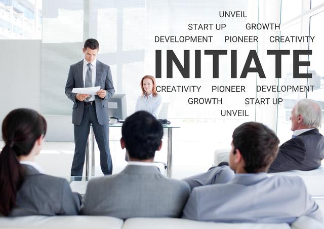Corporate presentation scene featuring team members in suits, seated and attentive, listening to a speaker. Background displays motivational keywords like ‘Initiate,’ ‘Development,’ ‘Pioneer,’ reflecting focus on innovation and growth. Suitable for business and leadership materials, team-building content, motivational talks, and corporate training presentations.
