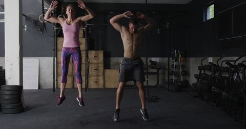 Athletic Duo Mastering Intense Burpees in Gym