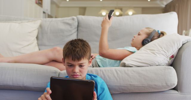 Siblings Using Technology Gadgets in Modern Living Room - Download Free Stock Images Pikwizard.com