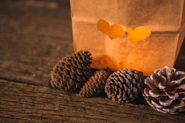 Paper bag and pine cone on wooden table