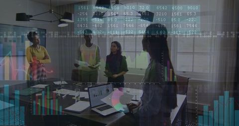Businesswomen Collaborating over Data Dashboards and Laptop Charts in Modern Boardroom