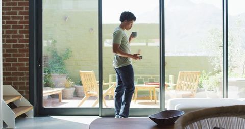 Man Drinking Coffee and Using Smartphone by Patio Glass Door - Download Free Stock Images Pikwizard.com